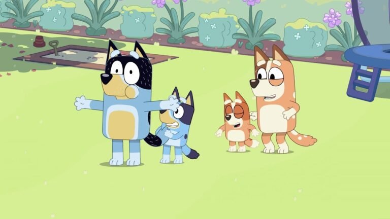 From the Bluey episode 'Keepy Uppy': Bandit and Bluey stand on a green lawn with arms outstretched, while Chilli and Bingo watch nearby with smiles. A sandbox and garden plants are visible in the background.